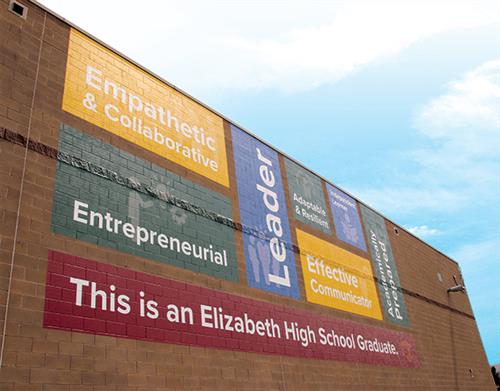 The exterior of EHS with the Profile of a Graduate graphic on the wall